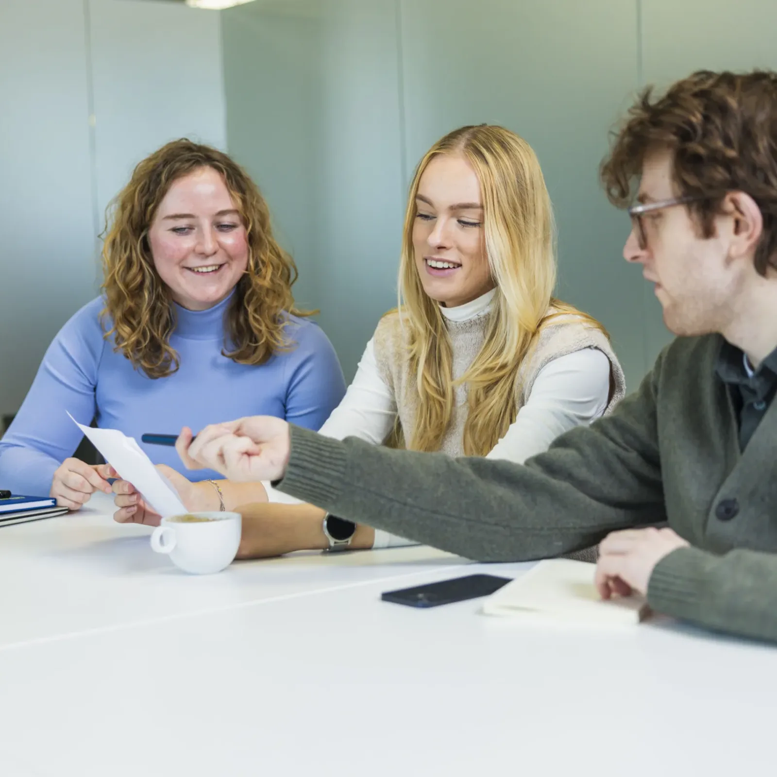 Marketeers en recruiter lachend in overleg.