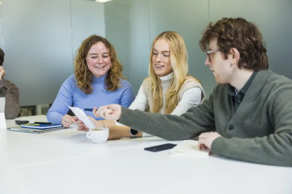 Marketeers en recruiter lachend in overleg.
