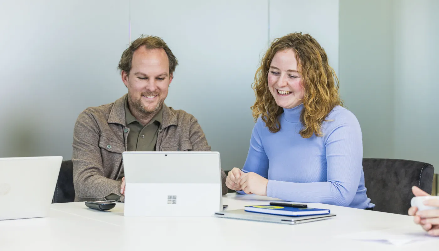 Employer branding adviseurs lachend in meeting.