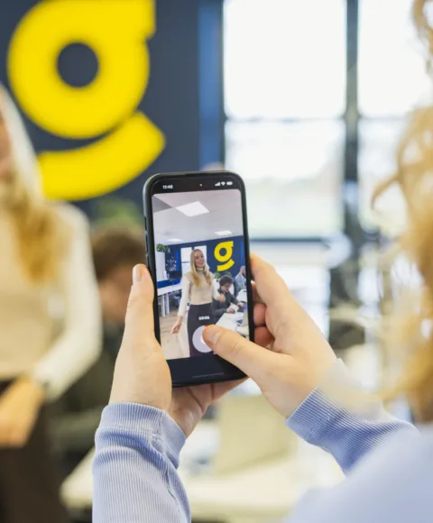 Marketing collega filmt recruitment collega met haar telefoon voor de vacature content marketeer.