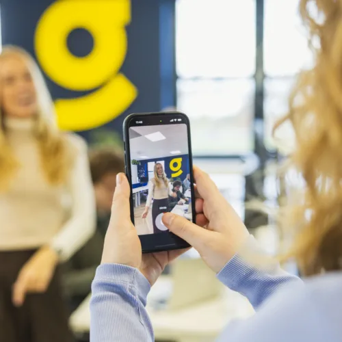 Marketing collega filmt recruitment collega met haar telefoon voor de vacature content marketeer.