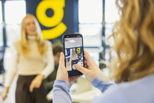 Marketing collega filmt recruitment collega met haar telefoon voor de vacature content marketeer.