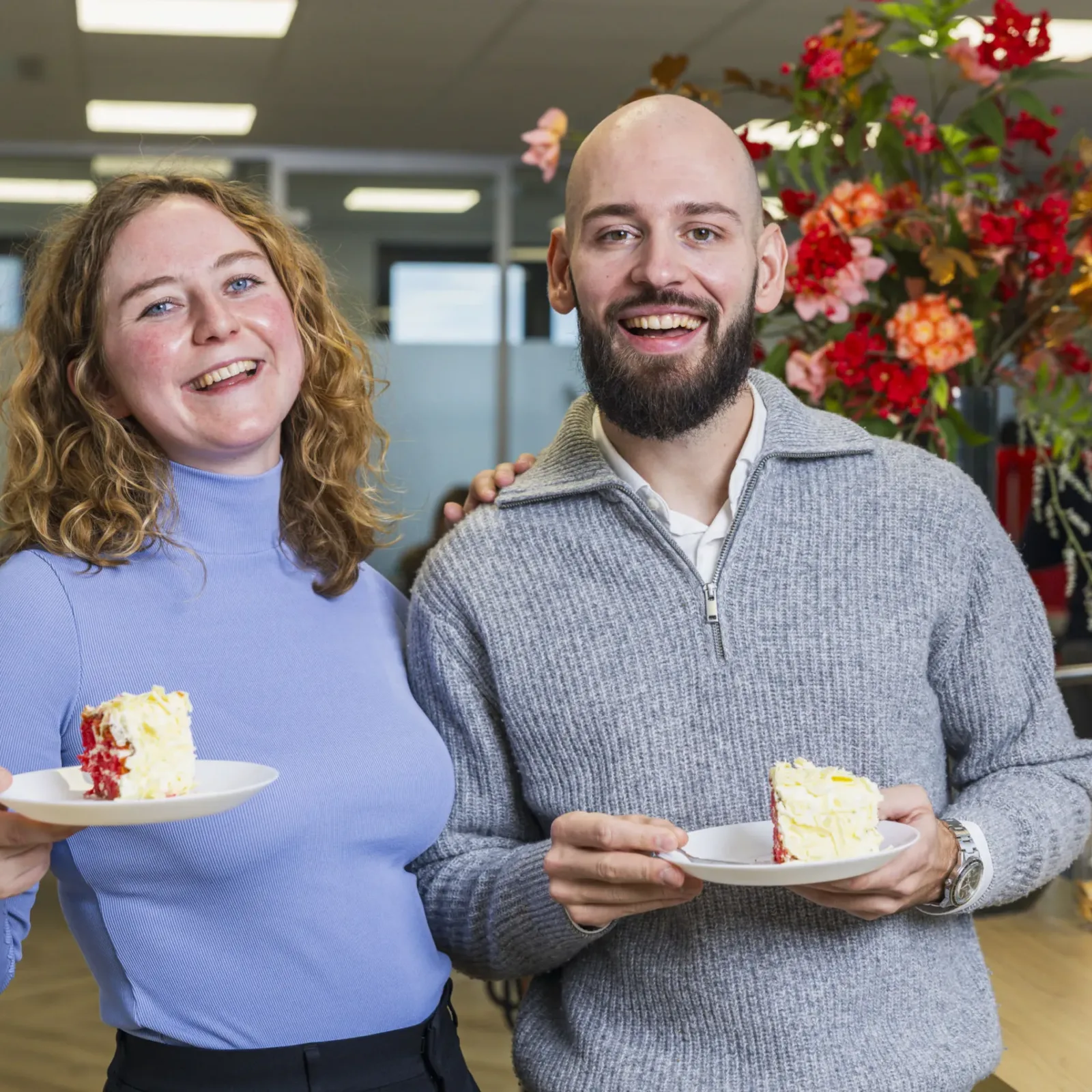 Collega's lachend met taart geposeerd