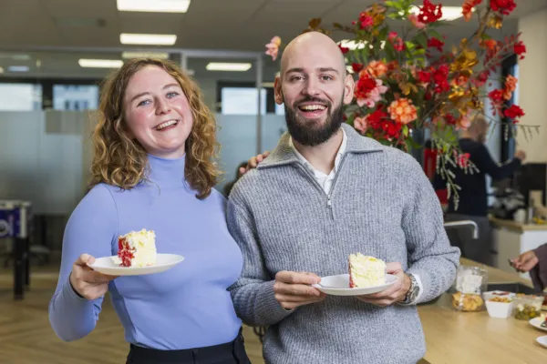 Collega's lachend met taart geposeerd